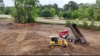 Dump truck and dozer placing and spreading fill on a cleared Charleston-area site