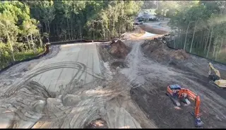 Excavator working a mass-graded pad on a Lowcountry development